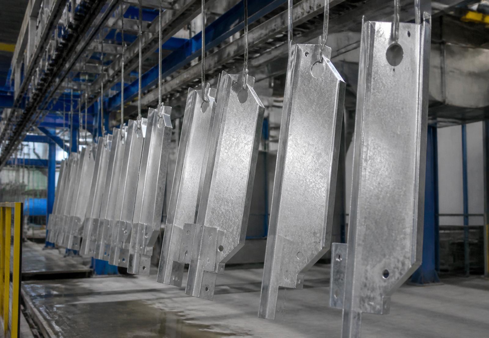Ocynkowane elementy stalowe zawieszone na linii technologicznej
